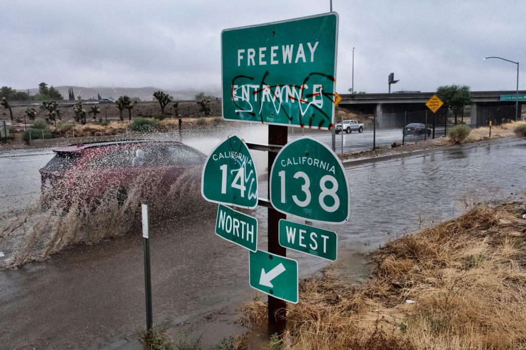 A vehicle engulfed in water drives through 