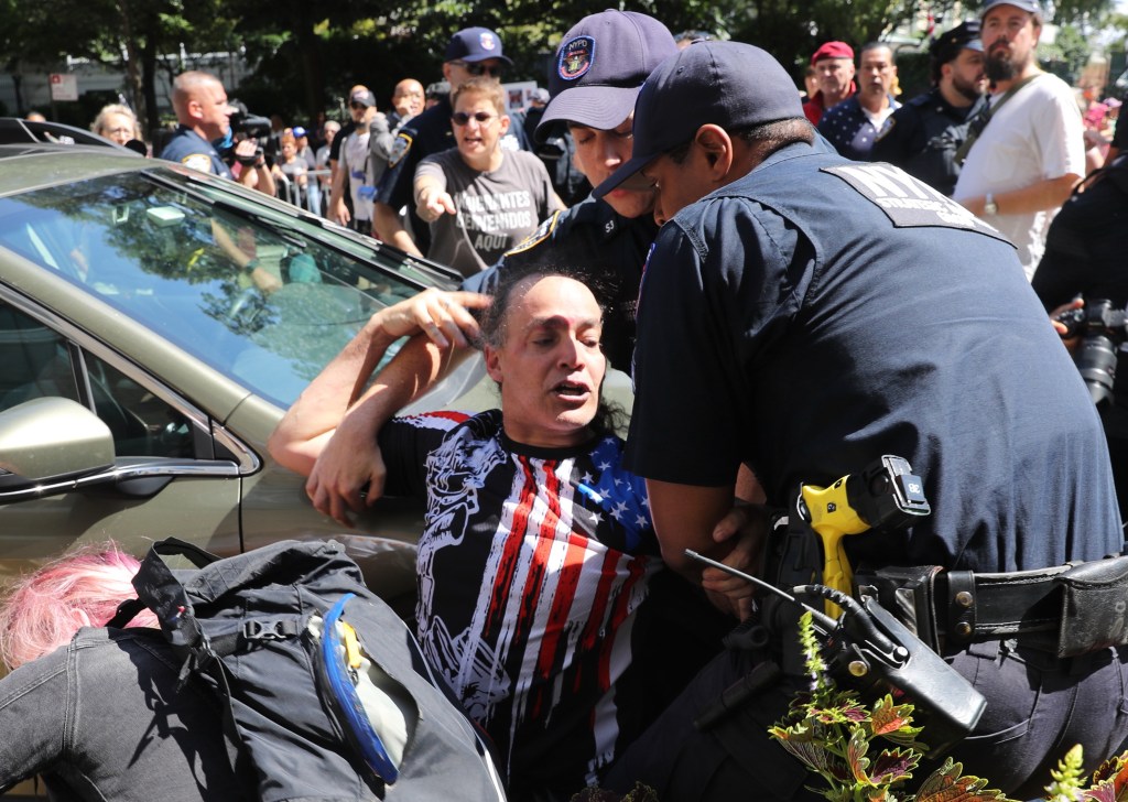 One of the protesters is shown clashing with police outside Gracie Mansion Sunday afternoon. 