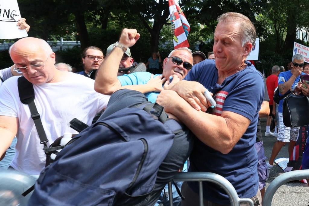 A counter protestor gets into a physical confrontation with an anti-migrant protestors during a rally and protest outside of Gracie Mansion on Sunday.