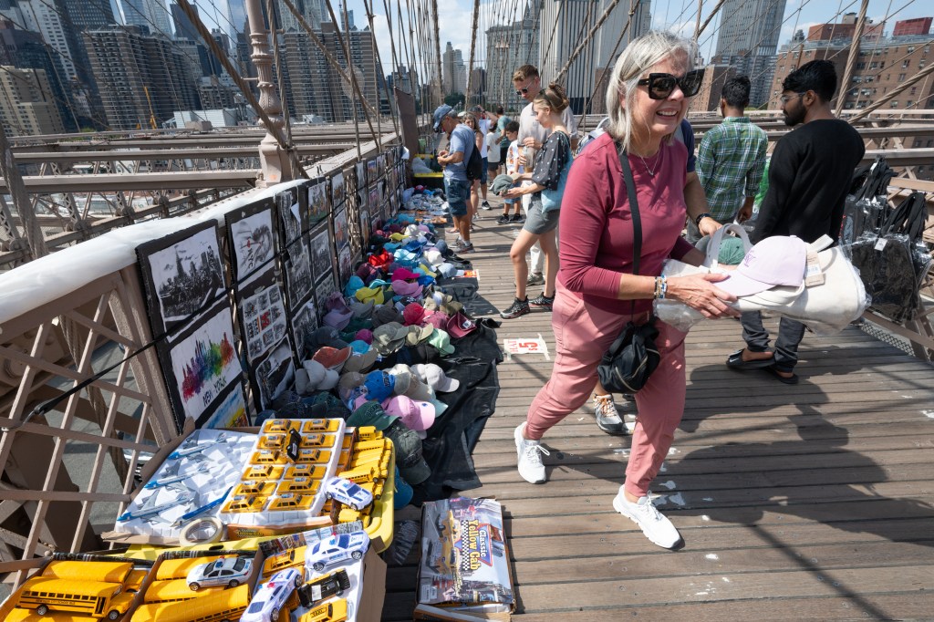 Tourists check out vendors on the Brooklyn Bridge.