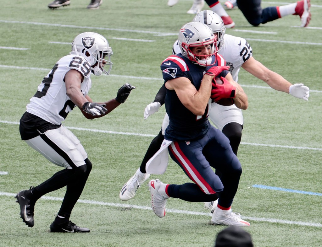 New England Patriots wide receiver Julian Edelman (11) turns up field between Las Vegas Raiders safety Lamarcus Joyner (29) and Raiders safety Erik Harris (25) during a game on September 27, 2020, at Gillette Stadium in Foxborough, Massachusetts.  