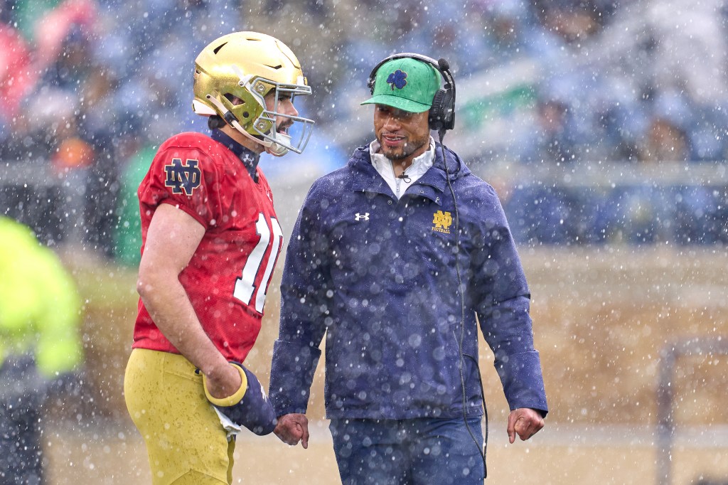 Notre Dame Fighting Irish head coach Marcus Freeman chats with quarterback Sam Hartman