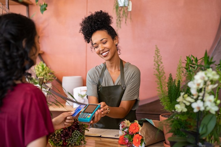 Millennial pays by credit card at the florist