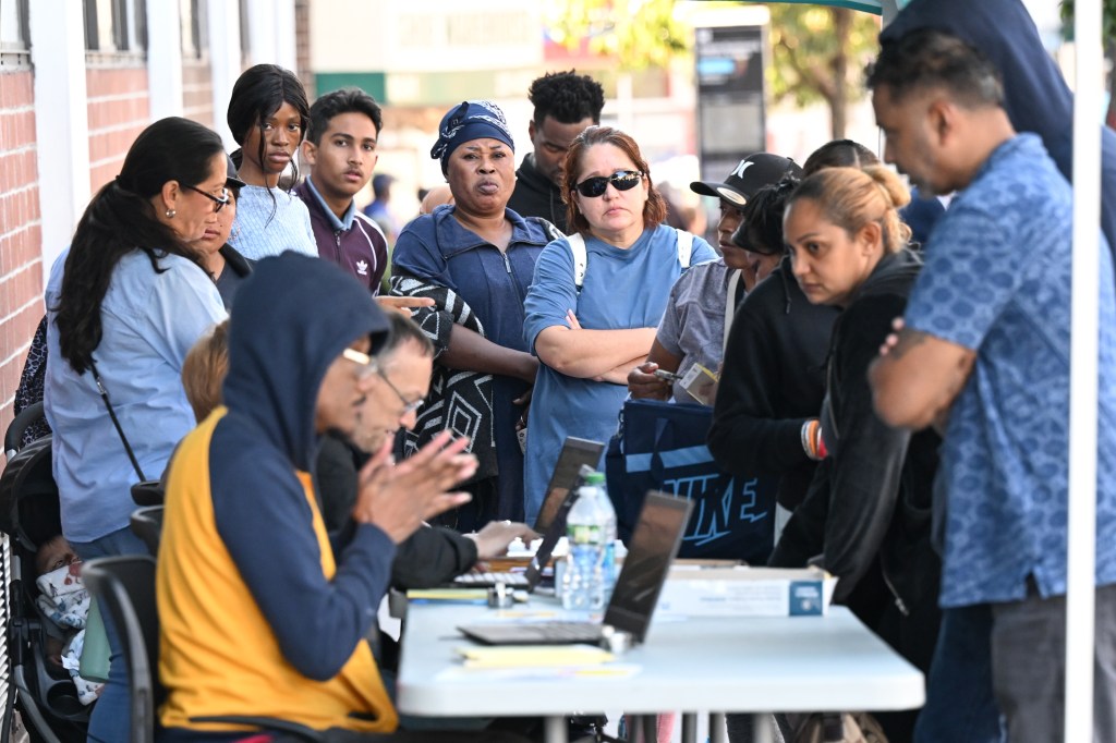 Families check in at the Department of Education's Welcome Center in Jamaica less than a week before school starts to handle enrollment issues.