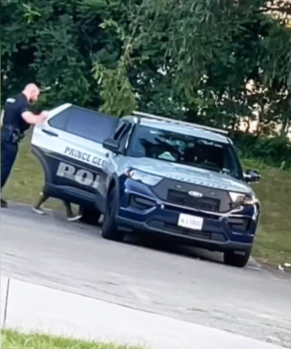 Police officer getting into his car with a woman