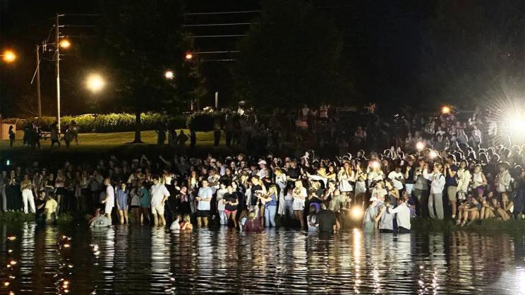 Auburn football coach Hugh Freeze assisted in in a worship event where nearly 200 students were baptized at.