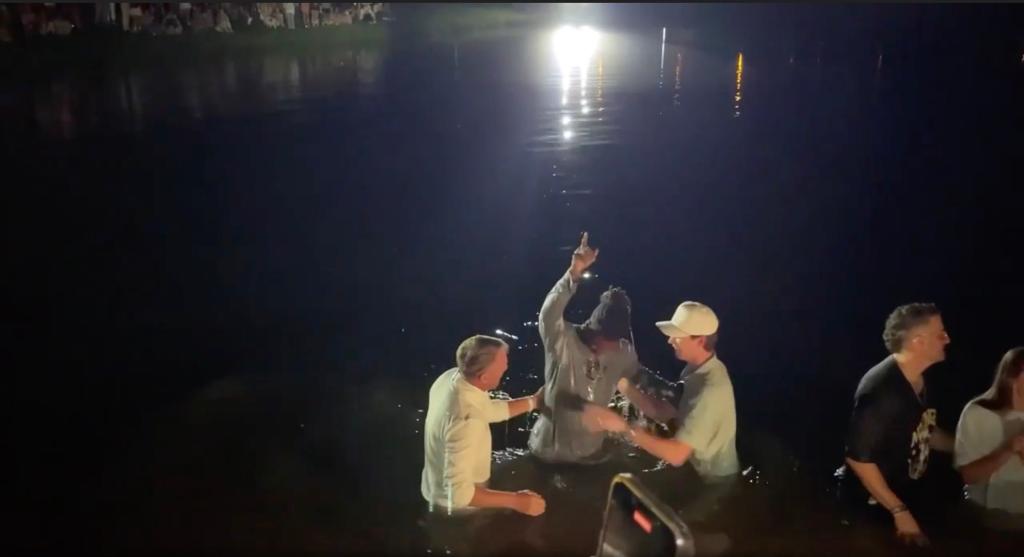 Auburn Tigers head football coach Hugh Freeze assists in the baptism of one of the school's football players