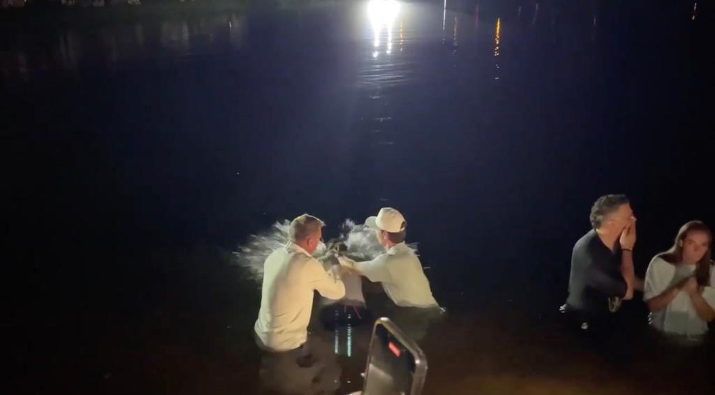 The baptisms took place Tuesday night in a lake at Auburn's Red Barn venue, which is located about half a mile from Auburn University's Neville Arena