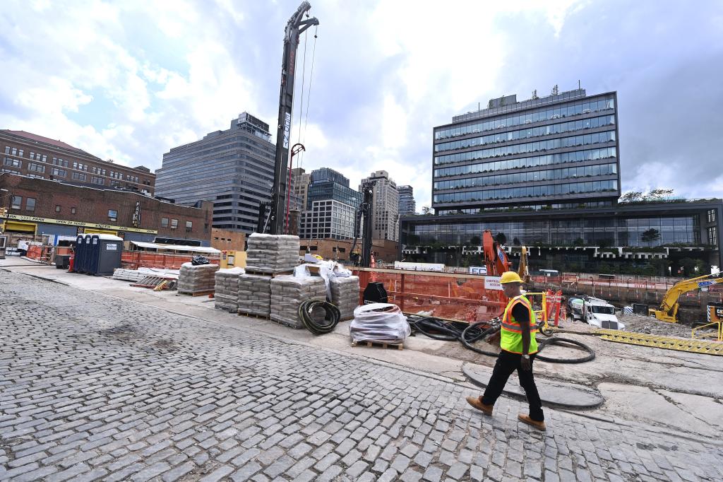 construction worker walking in front of buildings