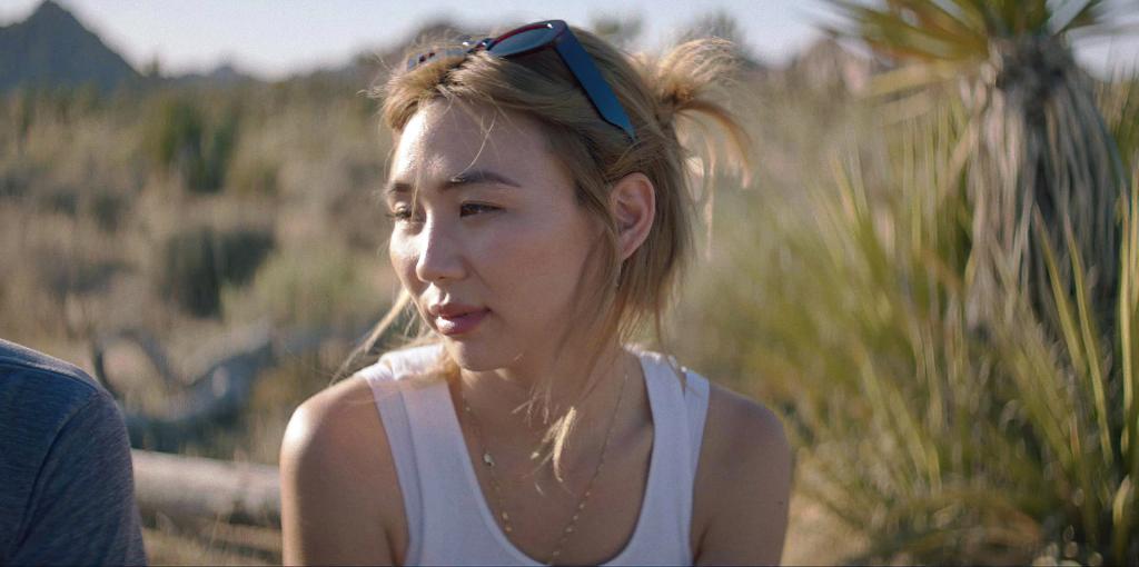 Rachel Lee wearing a white tank top in the desert. 