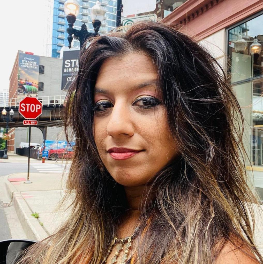 Picture of Lina Trivedi smiling near a stop sign