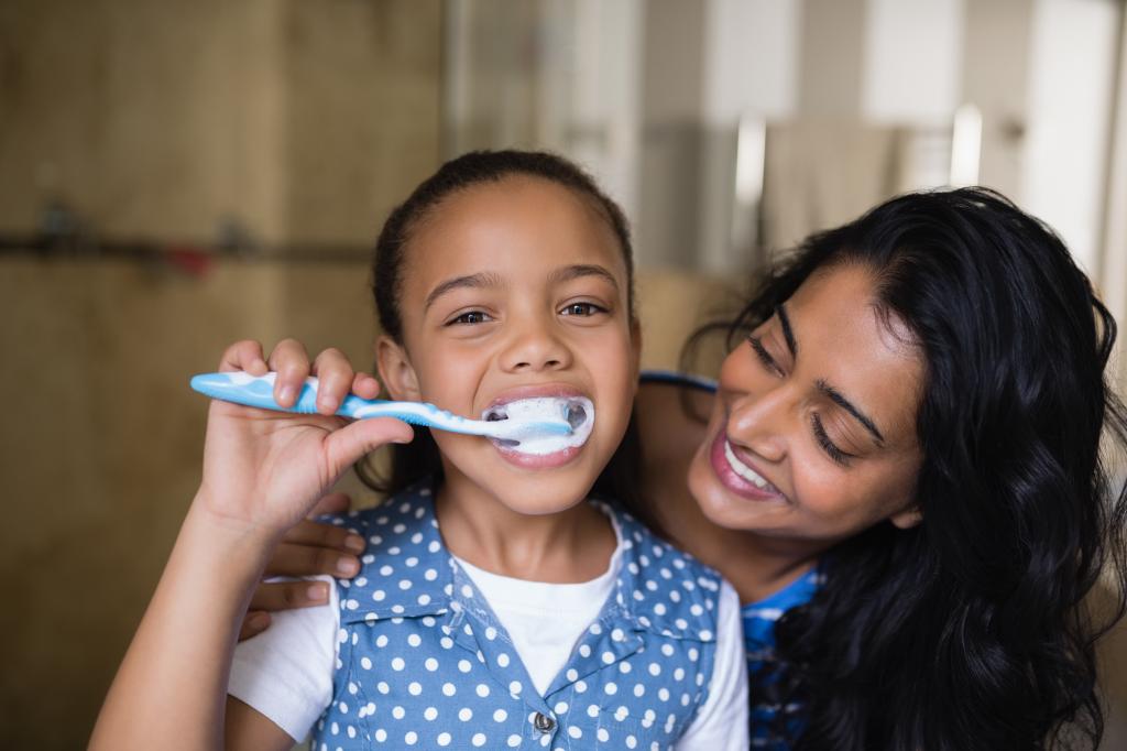 Photo of a parent brushing their child's teeth.