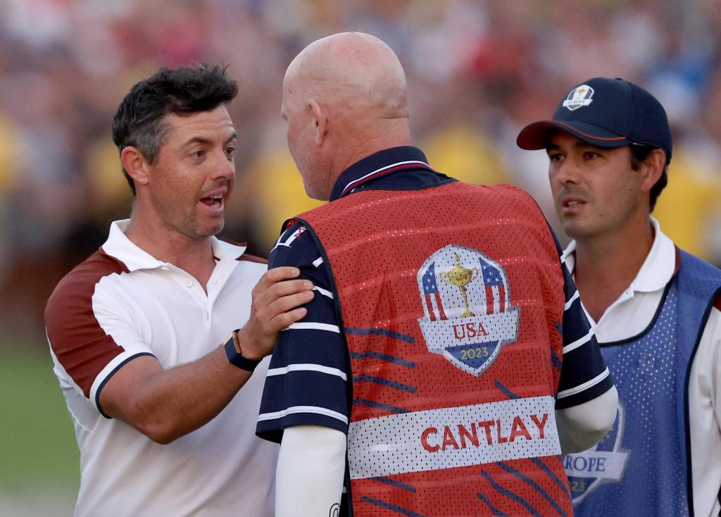  Rory McIlroy of Team Europe speaks with caddie of Patrick Cantlay of Team United States, Joe LaCava, on the 18th green