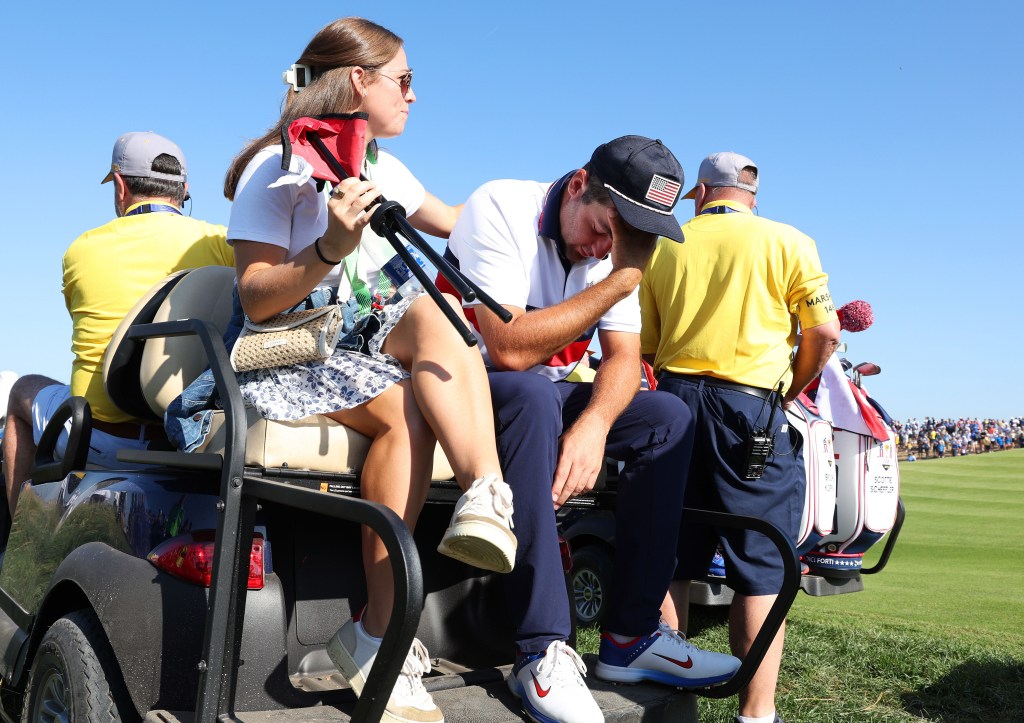 A tearful Scottie Scheffler is consoled by his wife, Meredith, after he and Brooks Koepka suffered the worst loss in a Ryder Cup singles match. 
