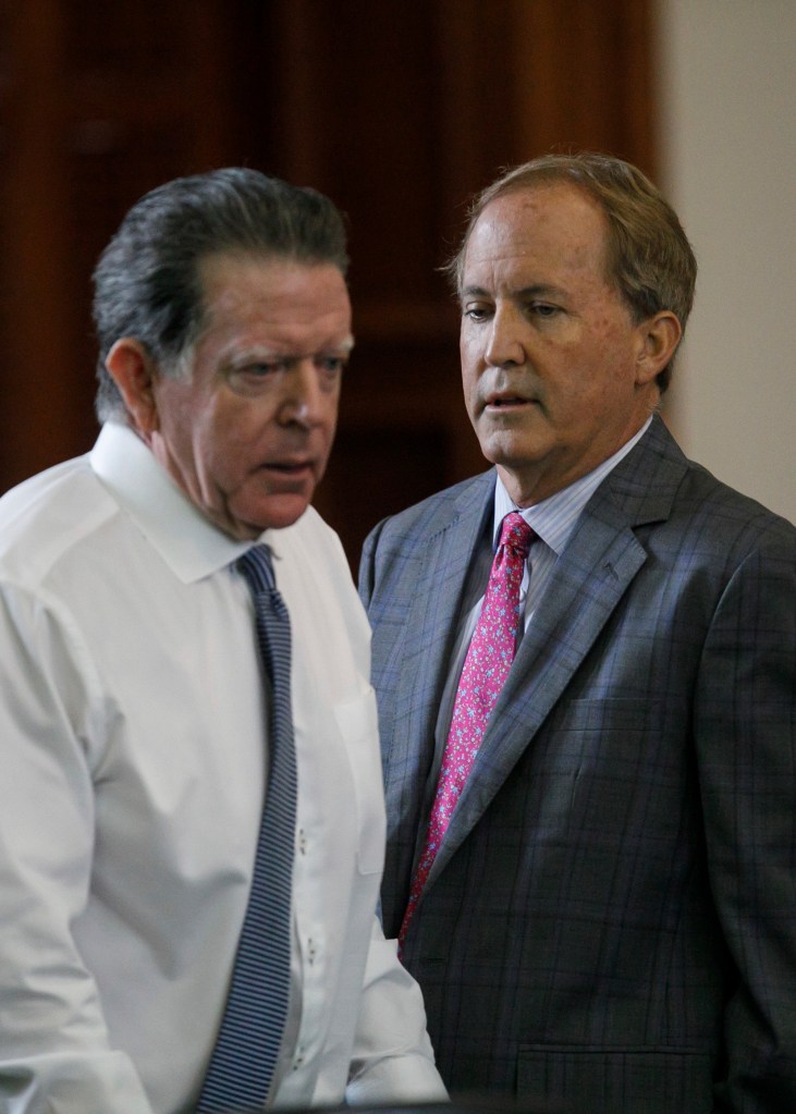 Texas Attorney General Ken Paxton, right, walks back to his seat after speaking privately with defense attorney Dan Cogdell, left, before his impeachment trial resumes in the Senate Chamber at the Texas Capitol on Friday, Sept. 15, 2023, in Austin, Texas. 