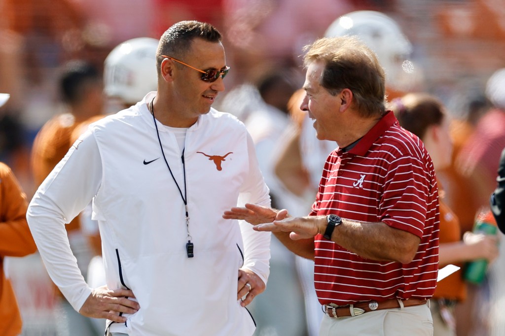 Head coach Steve Sarkisian of the Texas Longhorns talks with head coach Nick Saban of the Alabama Crimson Tide