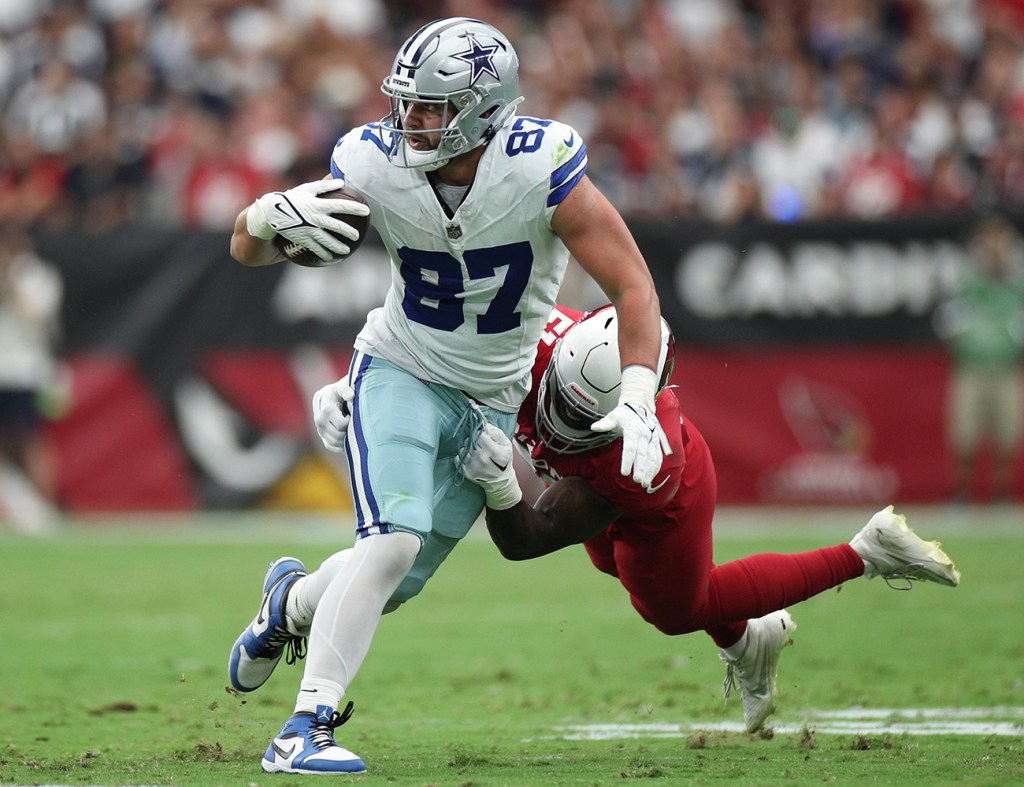 Jake Ferguson #87 of the Dallas Cowboys dodges a tackle attempt by Krys Barnes #51 of the Arizona Cardinals during the second quarter of a game at State Farm Stadium on September 24, 2023 in Glendale, Arizona. 