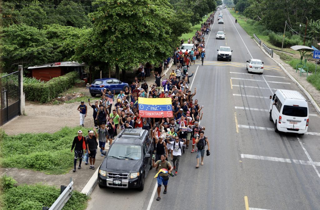 Aerial view of migrants holding flags of Venezuela and walking as part of a migrant caravan heading to the US through Mexico on July 15, 2023 in Ciudad Hidalgo, Mexico.