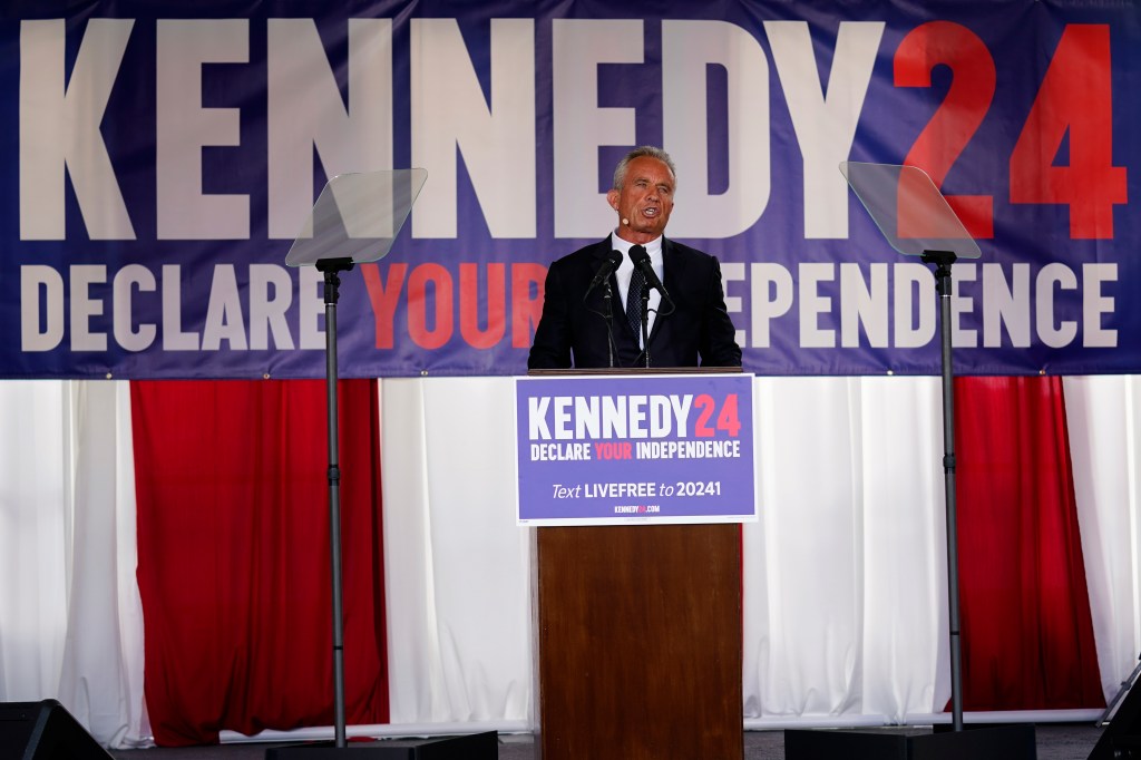 RFK Jr stands on stage behind a podium.
