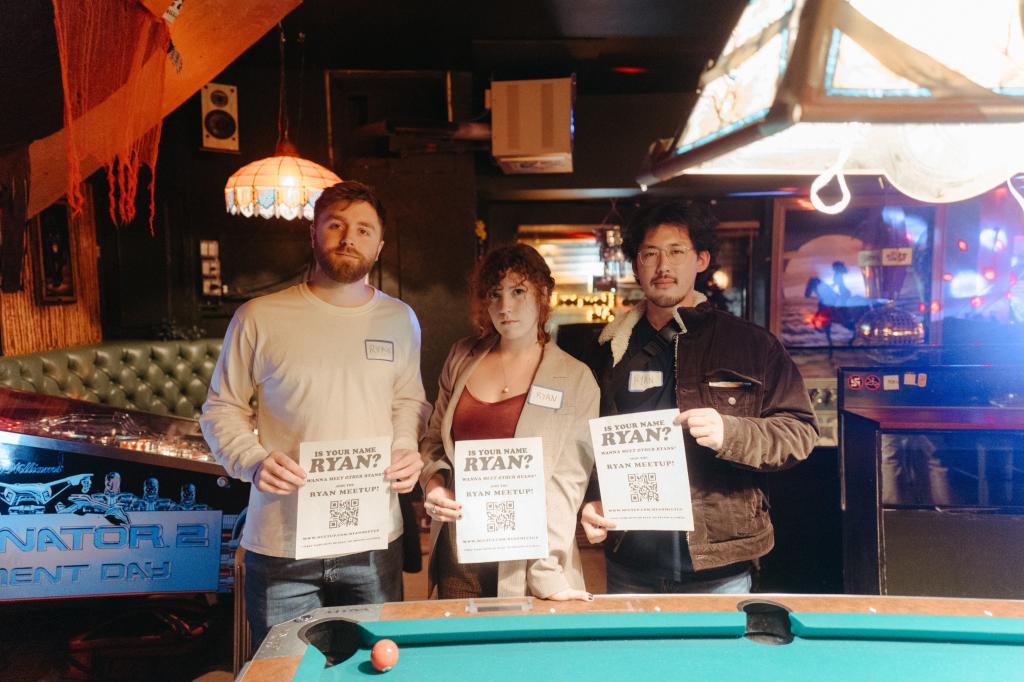 Ryan Rose (center) along with Ryan Cousins (L) and Ryan Le (R) are seen behind to a pool table at a bar.