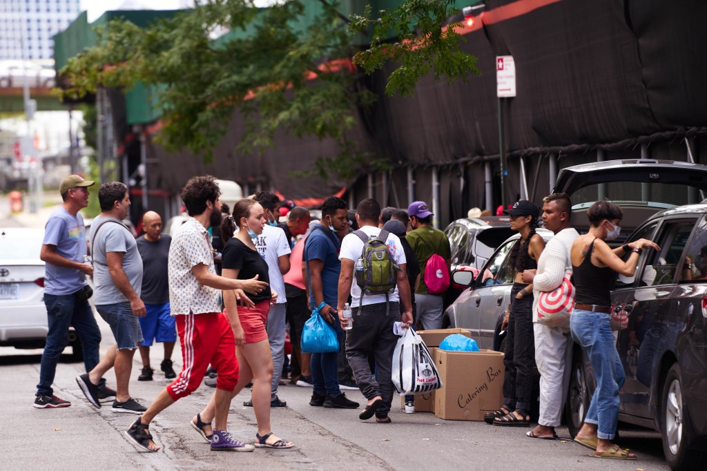 Migrants gather outside the 30th Street men's shelter in August 2022. 