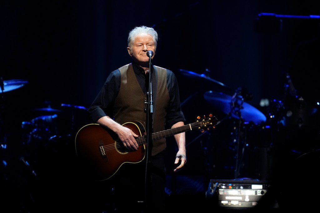 Eagles' Don Henley on stage standing with a guitar