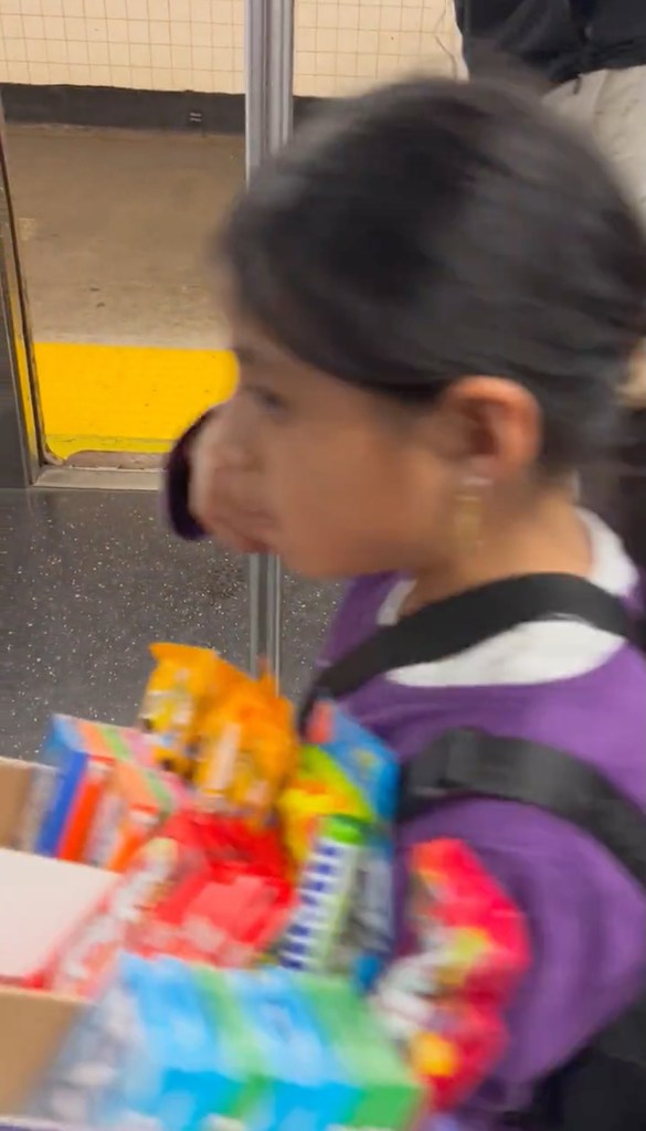 Screen shot from a video showing a young girl selling candy on the C train posted to twitter by @bronxilla