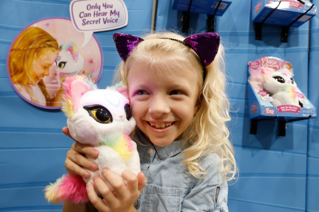 A little girl holding a plush toy.