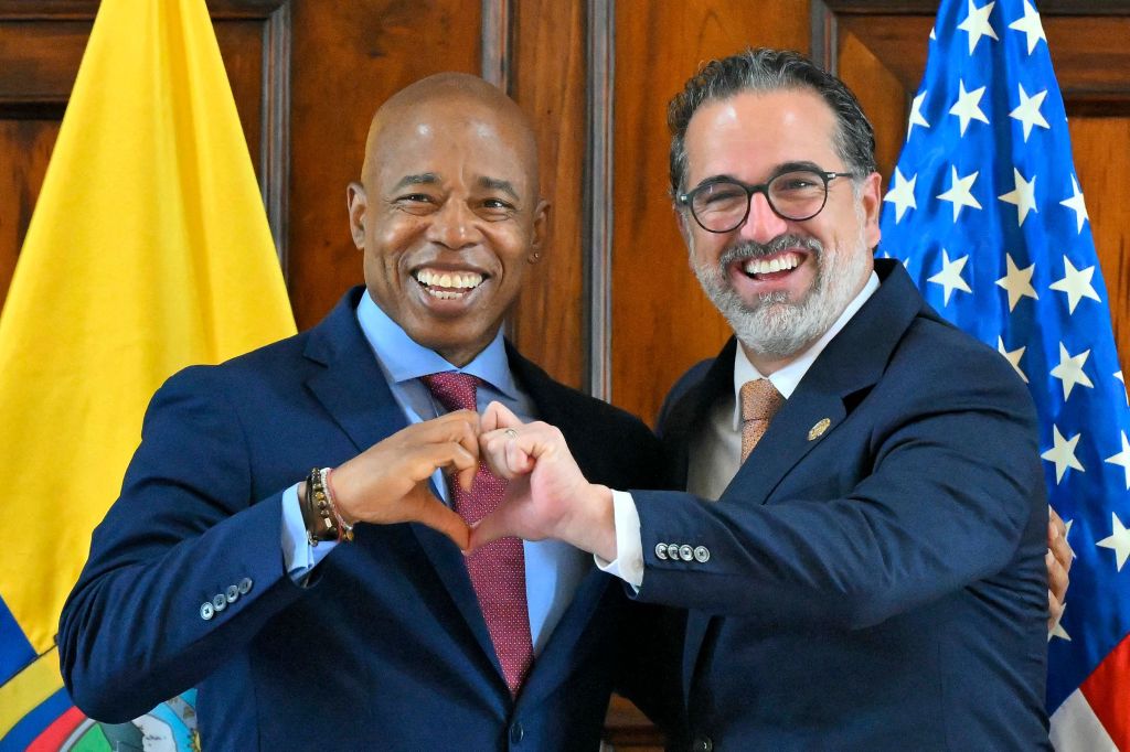 Adams and Ecuador's Foreign Minister Gustavo Manrique form a heart figure during a meeting at Najas Palace, which serves as the headquarters of the Foreign Ministry, in Quito, on Oct. 6. 