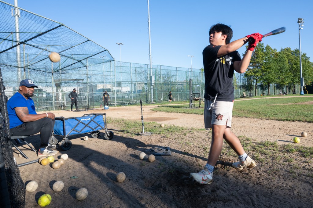 boy swinging a bat at Astor Little League in The Bronx