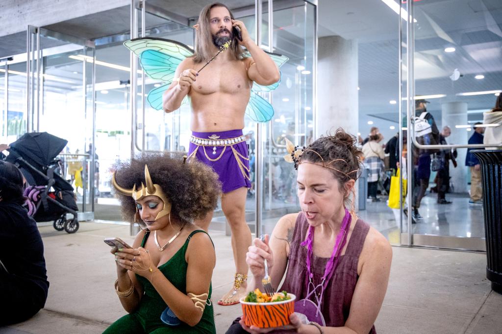 3 people in costume take a break to have lunch and make phone calls 