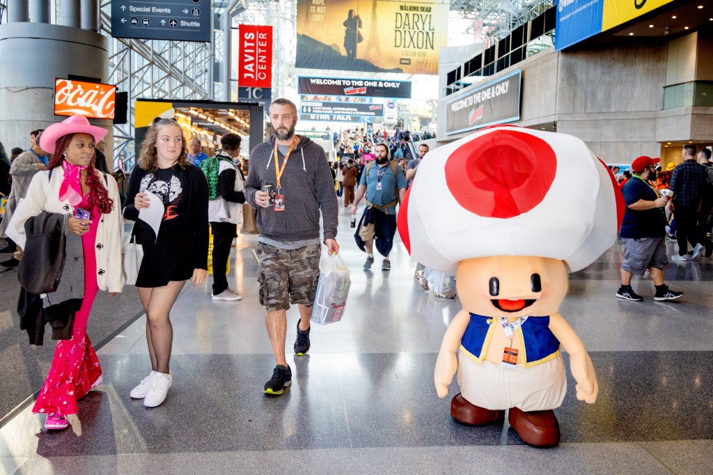 people in costumes walking around the javits center 