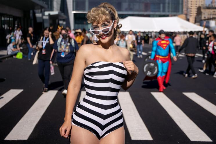 A woman wearing a black and white stripe bathing suite standing on the steps