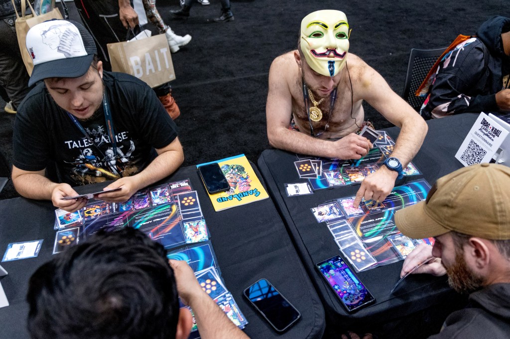 four men playing a card game while seated at a table