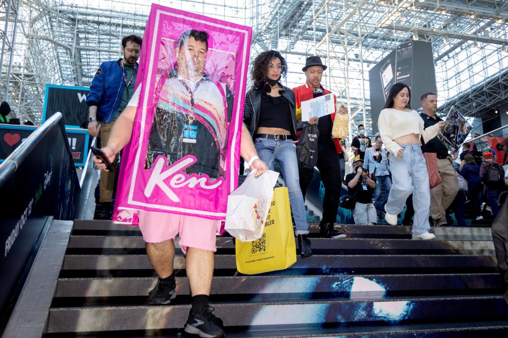 man wearing a pink box decorated to look like a ken doll package walking down the steps