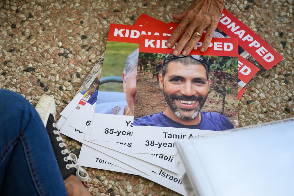 Photographs of the missing are seen as a "Shabbat Dinner" table is prepared at the Tel Aviv museum plaza, with 200 empty seats, representing the hostages.