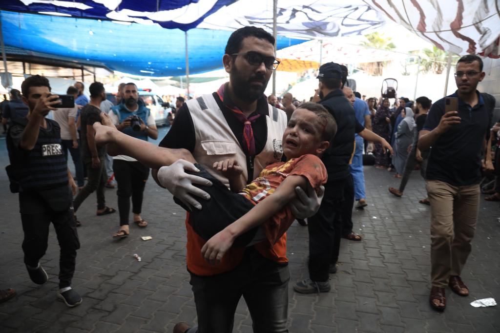 A rescue worker carrying an injured child to El- Shifa Hospital in Gaza City on October 25, 2023.