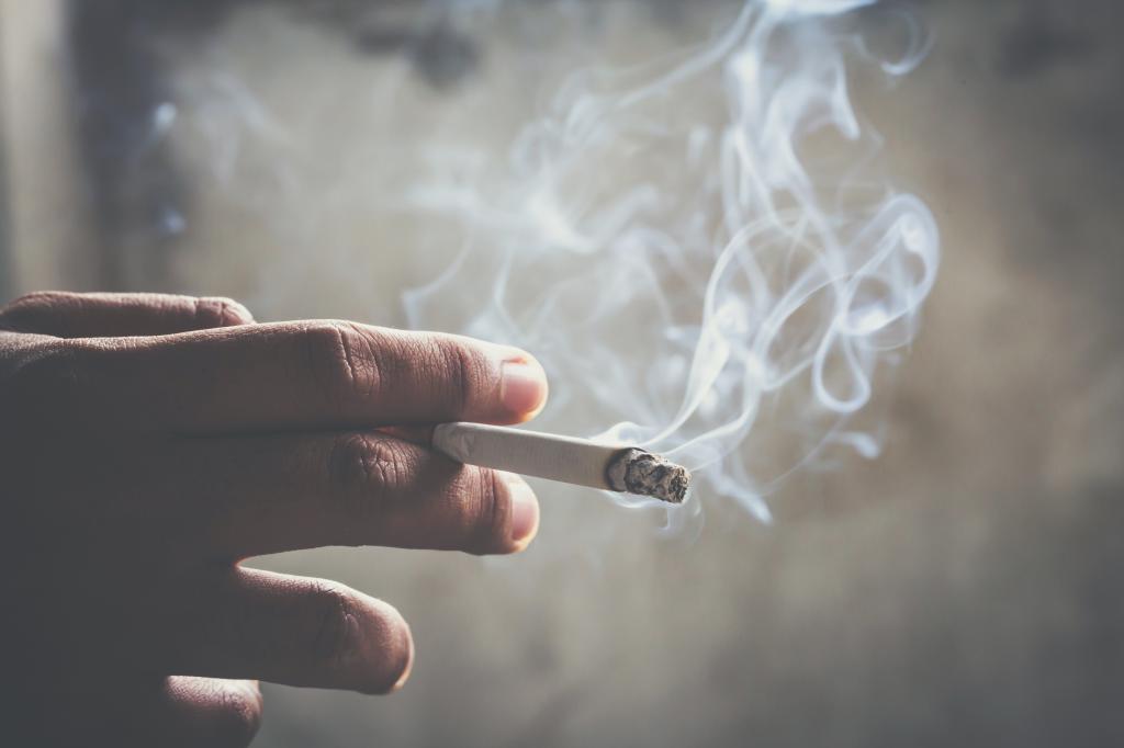 hand holding smoking cigarette