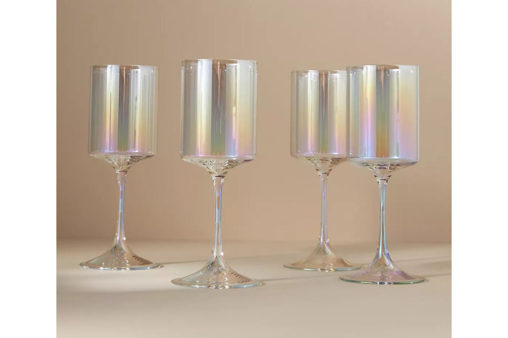 Iridescent wine glasses on beige background