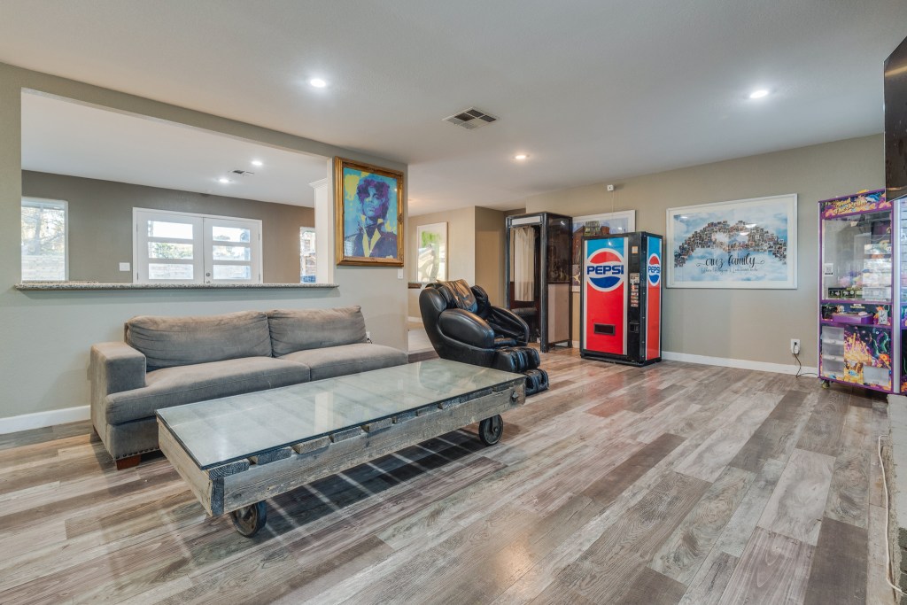 The living room with a couch and pop machine. 