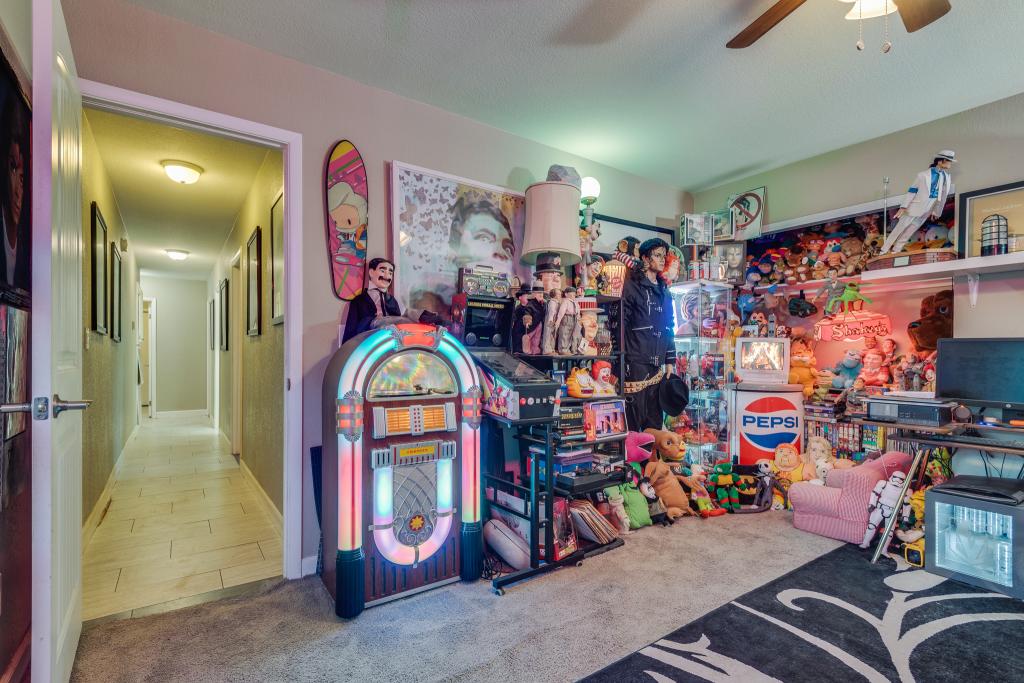 A different bedroom has access to the background and is currently being used as a storage room for knickknacks.