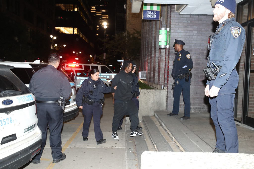 A suspect is seen going into the Midtown South Precinct, as they are taken away by police on Oct. 31, 2023. 