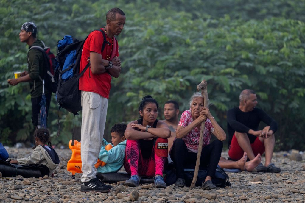 Migrants resting on the ground.