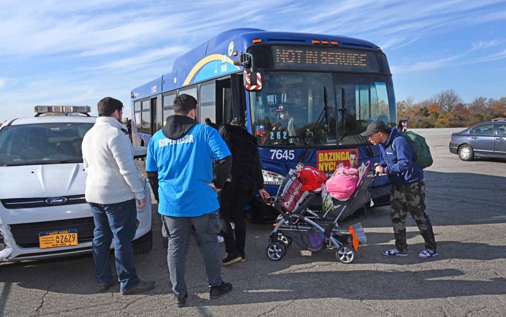 Migrants get back on a bus to leave after arriving at Floyd Bennett Field Sunday, Nov. 12, 2023