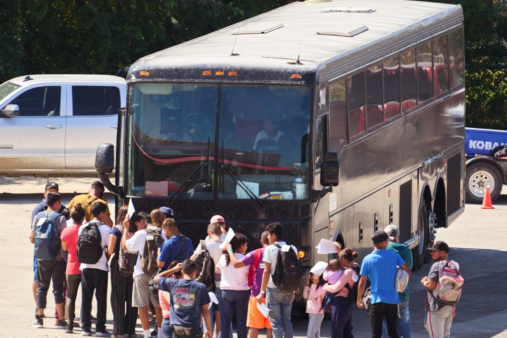 Migrants getting on a bus in Eagle Pass, Texas that will transport them to New York on September 22, 2023.