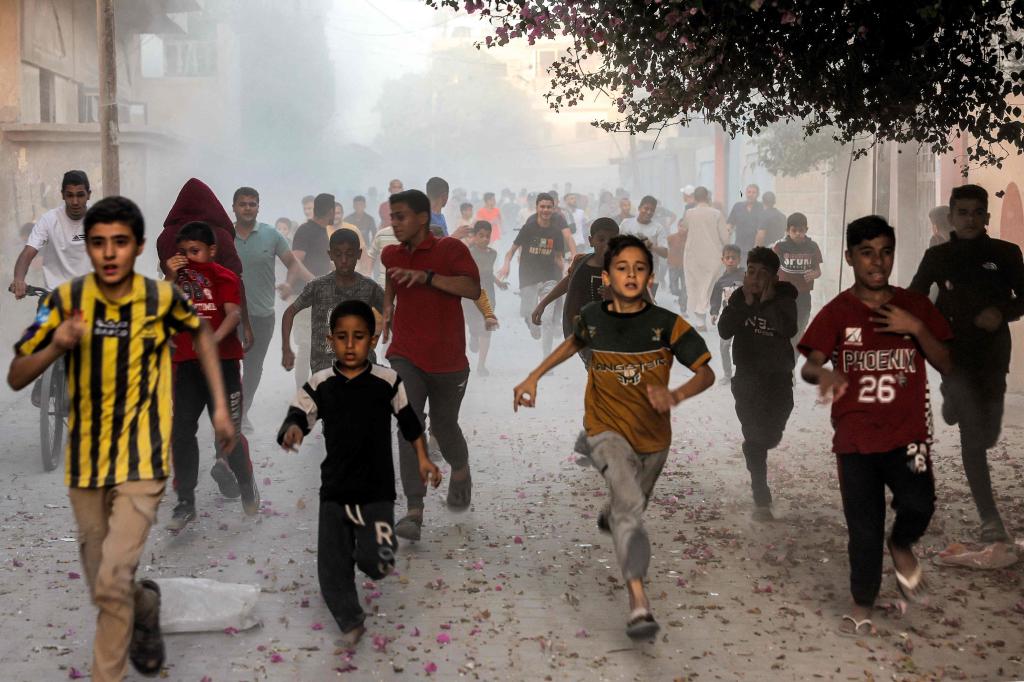 Palestinian children run as they flee from Israeli bombardment in Rafah in the southern Gaza Strip on November 6, 2023