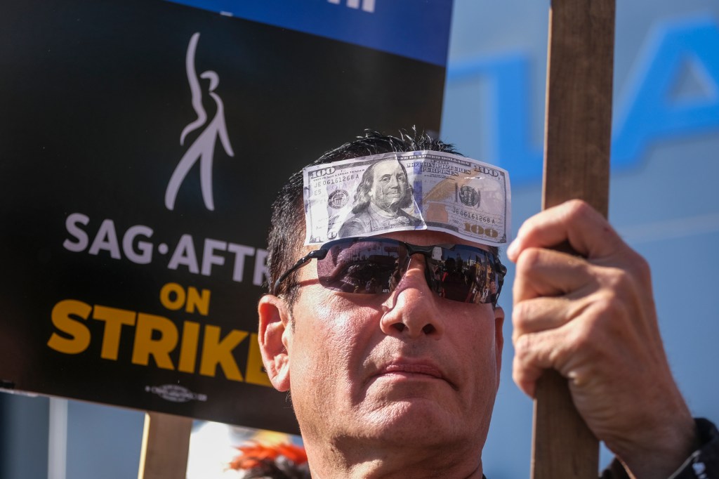 Striking SAG-AFTRA members walk with pickets outside Netflix studios, Wednesday, November 8, 2023, in Los Angeles