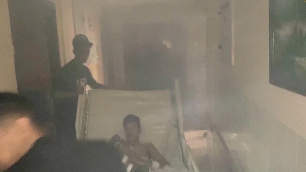 Israel conducted a raid on the hospital on Tuesday. The image above shows a medic move a patient through the smoke-filled corridors.