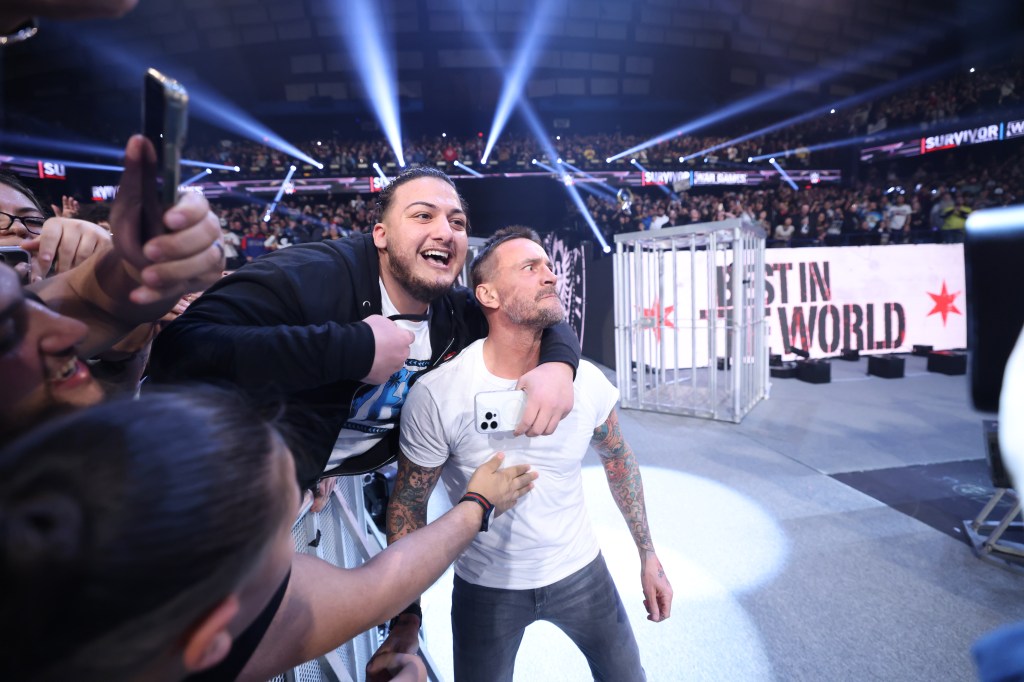 A fan wraps his arm around CM Punk at the end of WWE's Survivor Series.