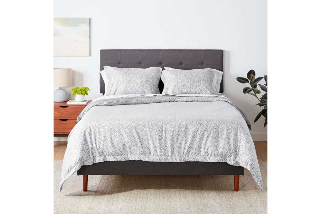 A bed with white and black polka dots bedding in a bedroom.